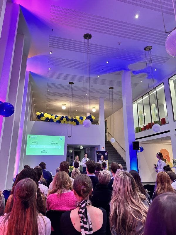 Pitch auf der Bühne vor vollem Saal bei einem Enactus-Abend in Münster